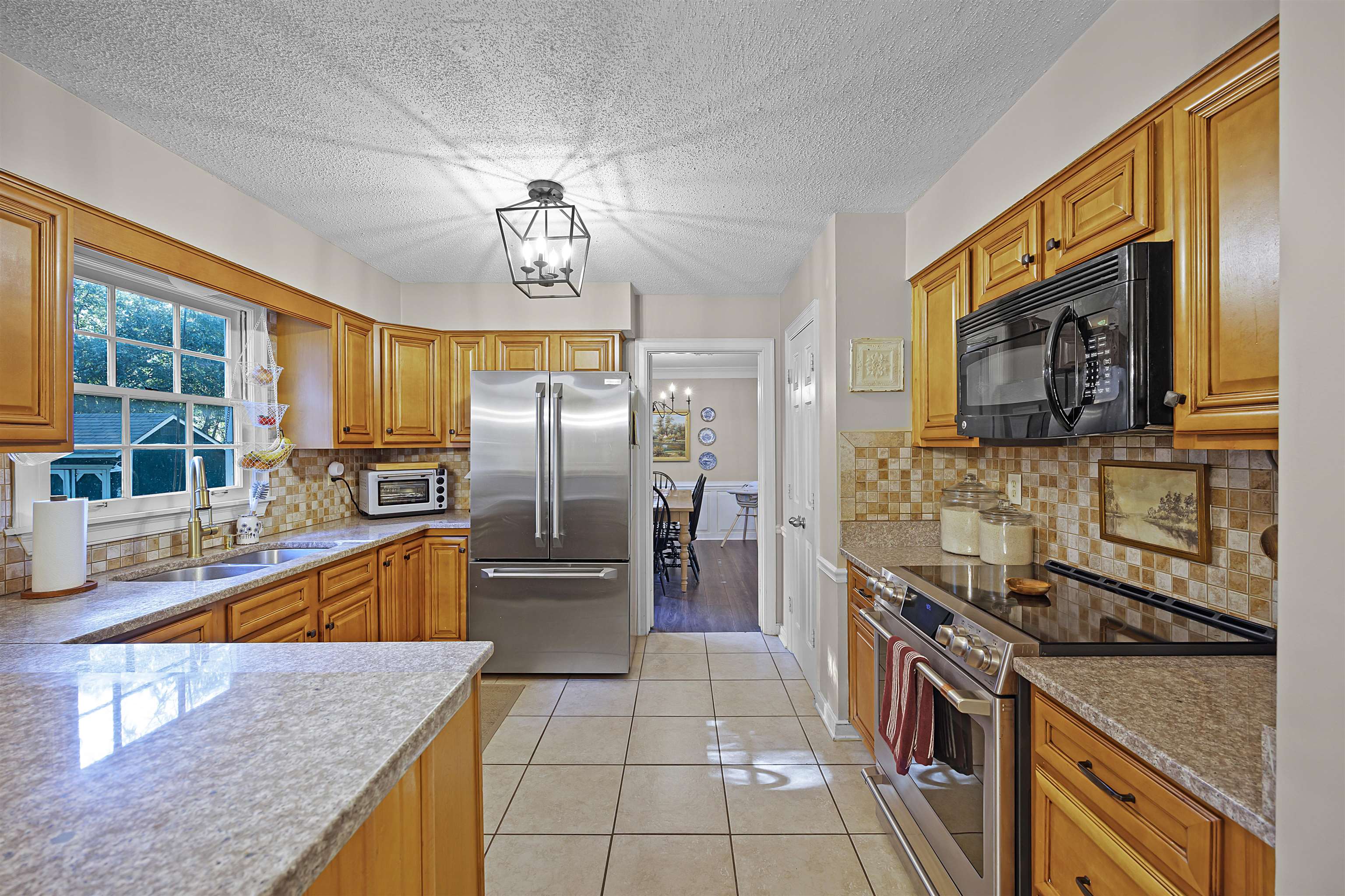 319 East Harpers Ferry Road Collierville, TN 38017 - Photo 8 of 27 Kitchen with sink, a textured ceiling, light tile patterned flooring, stainless steel appliances, and a chandelier