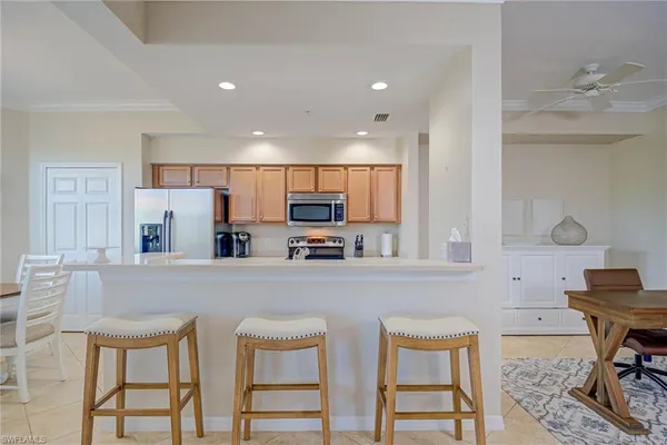 a kitchen with stainless steel appliances wooden floor dining table and chairs