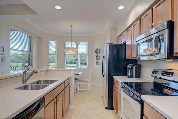 a kitchen that has a sink cabinets counter space and appliances