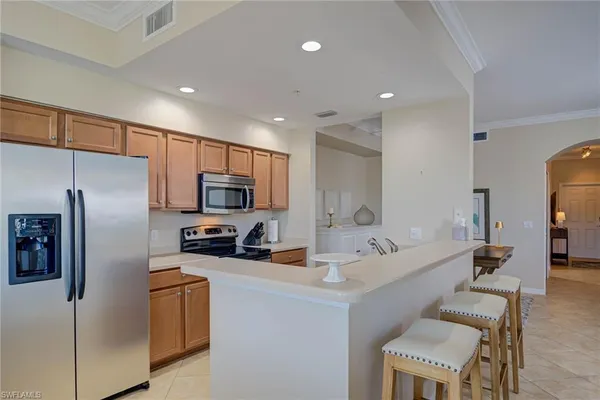 a large kitchen with stainless steel appliances a refrigerator and a stove top oven