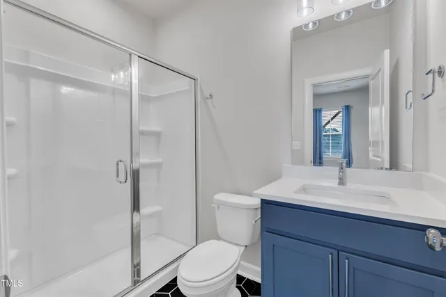 an empty room with wooden floor and a ceiling fan