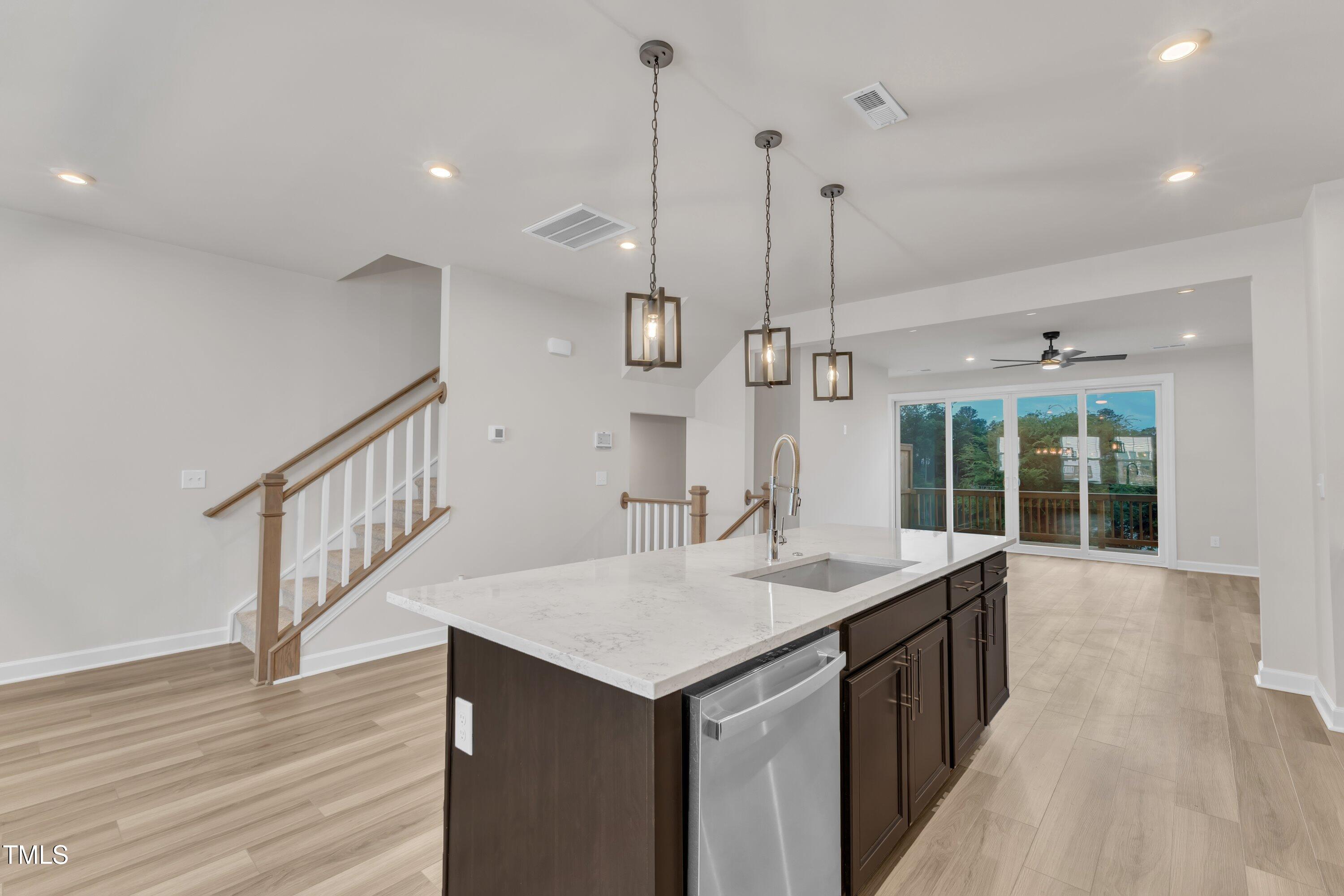 816 Lilyquist Way Wake Forest, NC 27587 - Photo 25 of 53 a kitchen with a sink a center island a wooden floor and a large window