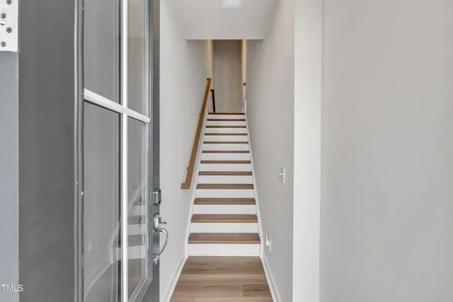 a view of a hallway with wooden floor and entryway