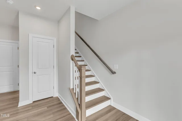 a view of a hallway with wooden floor and entryway
