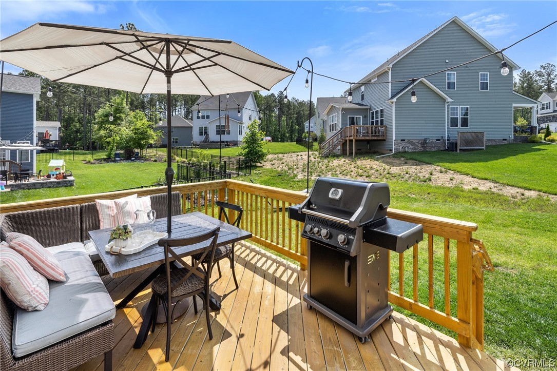 8125 Timberstone Drive Chesterfield, VA 23832 - Photo 32 of 34 a view of a patio with table and chairs under an umbrella with a garden