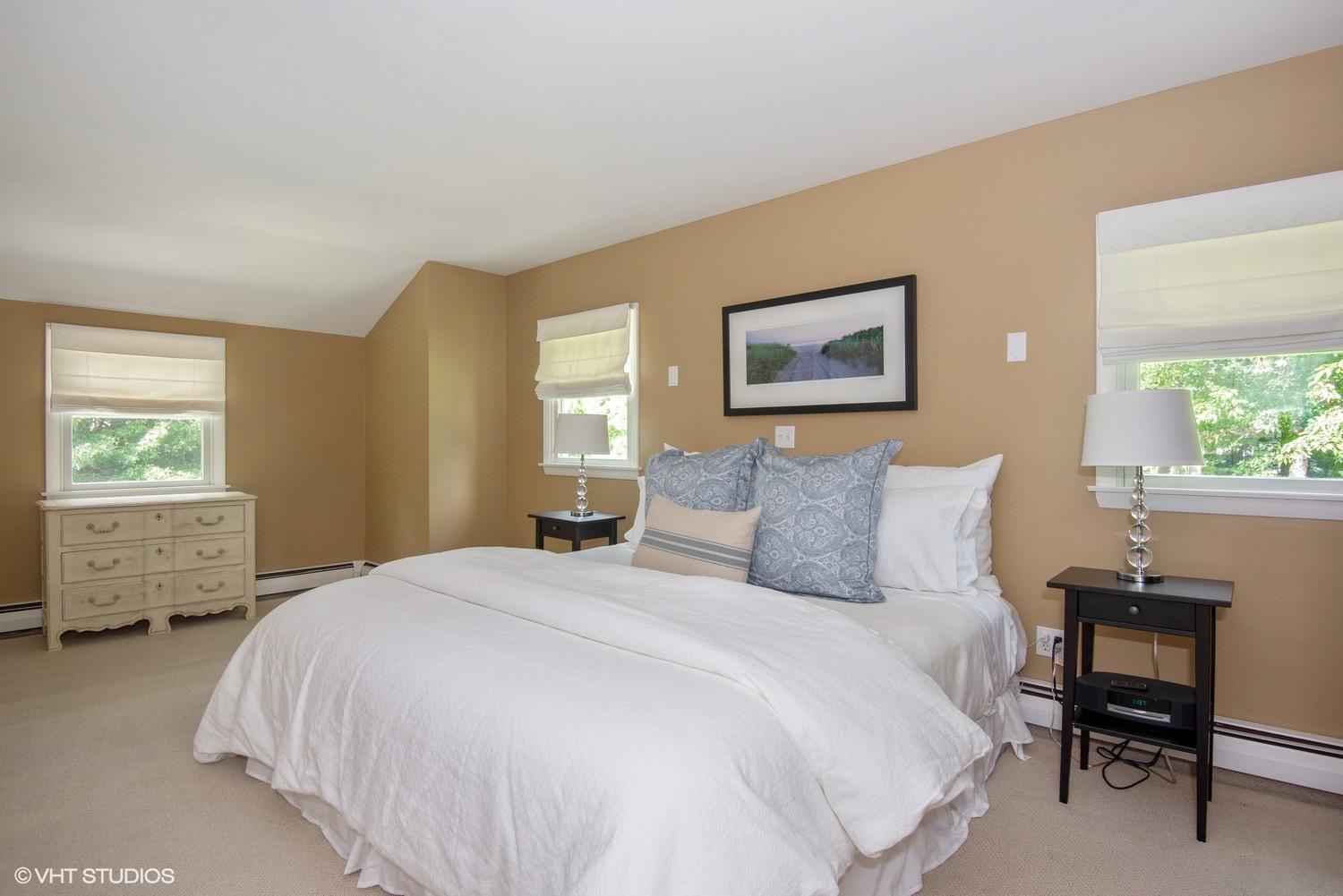 1166 Old Post Road Cotuit, MA 02635 - Photo 11 of 15 a bedroom with a bed a table and chair