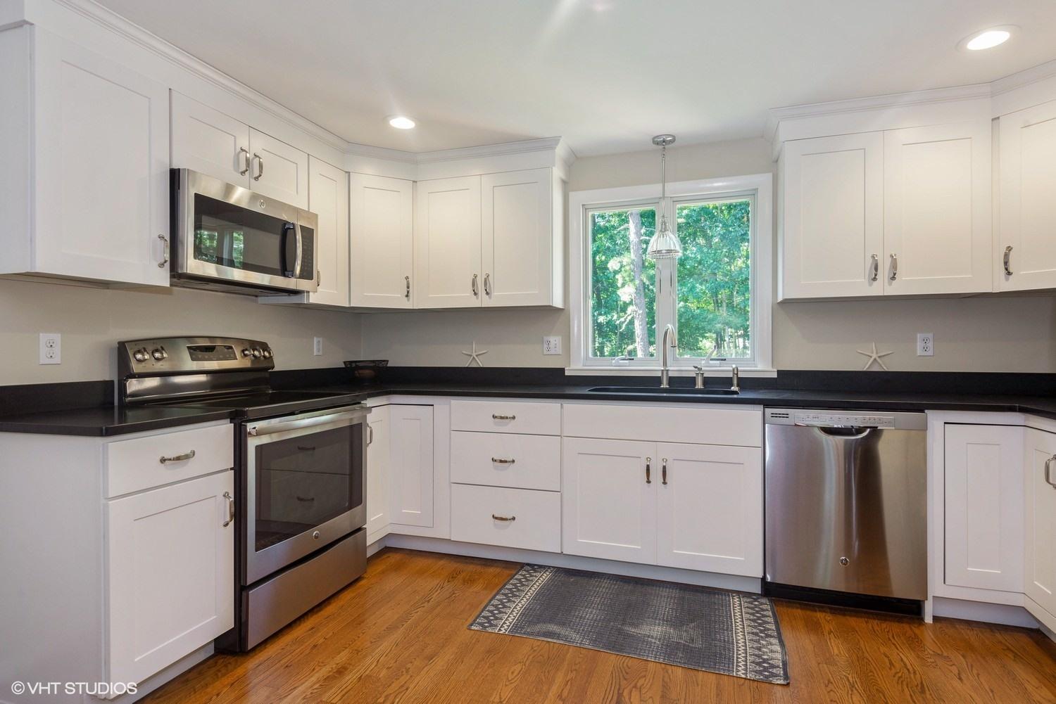 1166 Old Post Road Cotuit, MA 02635 - Photo 2 of 15 a kitchen with stainless steel appliances granite countertop a stove a sink and white cabinets