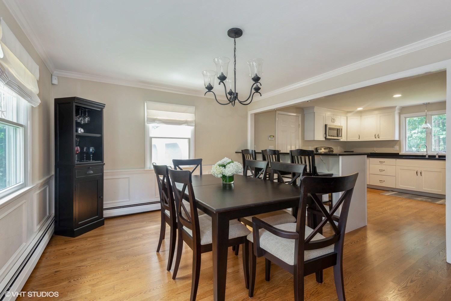 1166 Old Post Road Cotuit, MA 02635 - Photo 8 of 15 a view of a dining room and livingroom with furniture wooden floor a chandelier