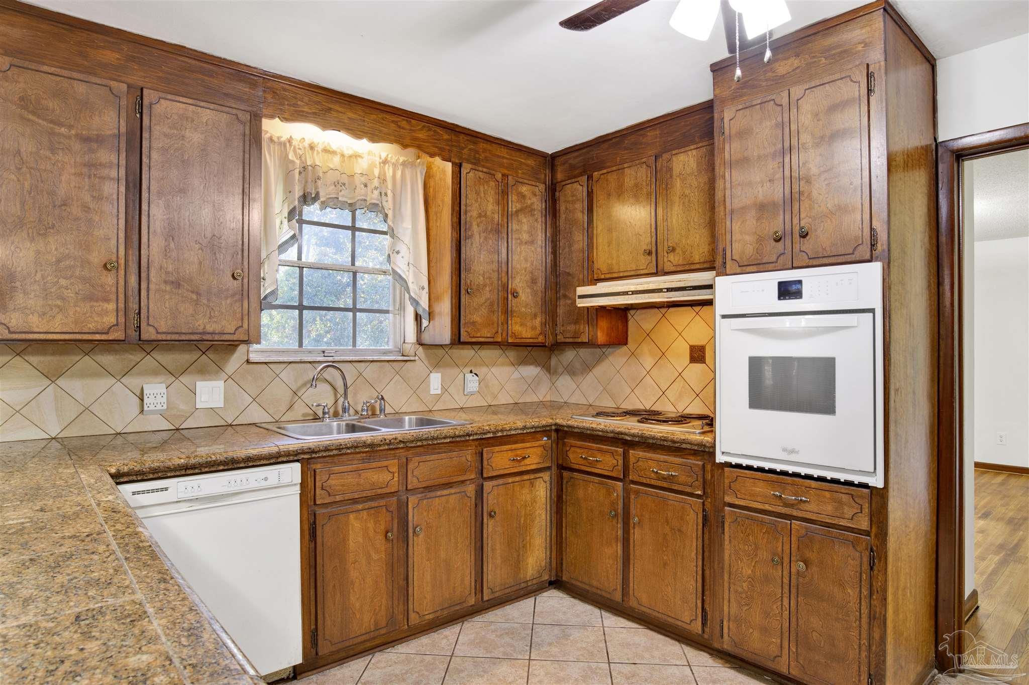 9621 Sidney Road Pensacola, FL 32507 - Photo 11 of 30 a kitchen with stainless steel appliances granite countertop a sink and a microwave