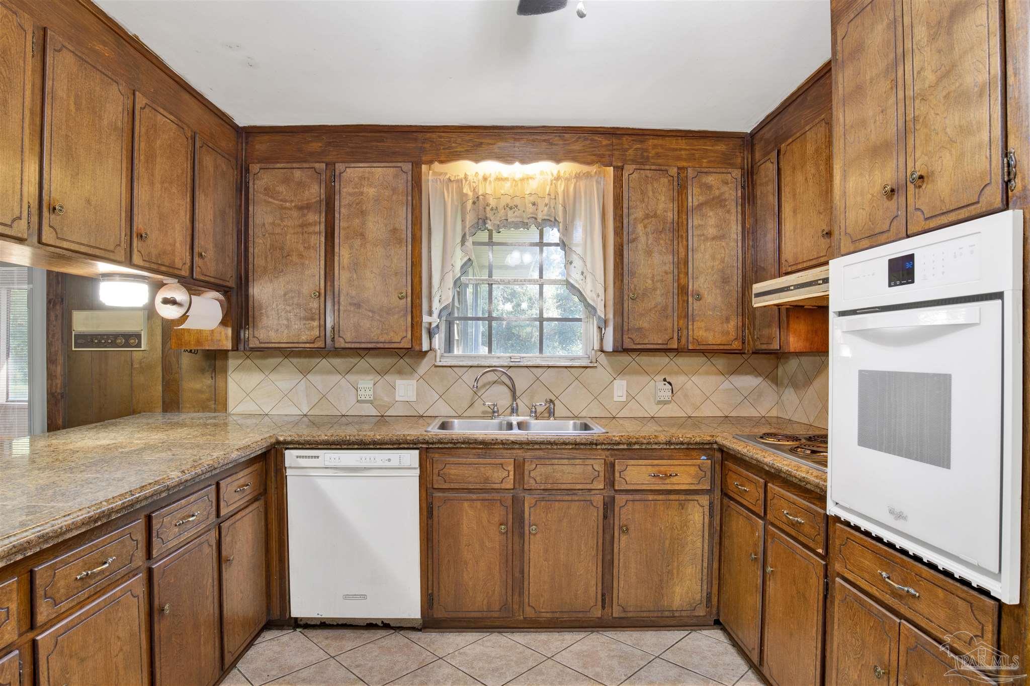 9621 Sidney Road Pensacola, FL 32507 - Photo 12 of 30 a kitchen with a sink stove and cabinets