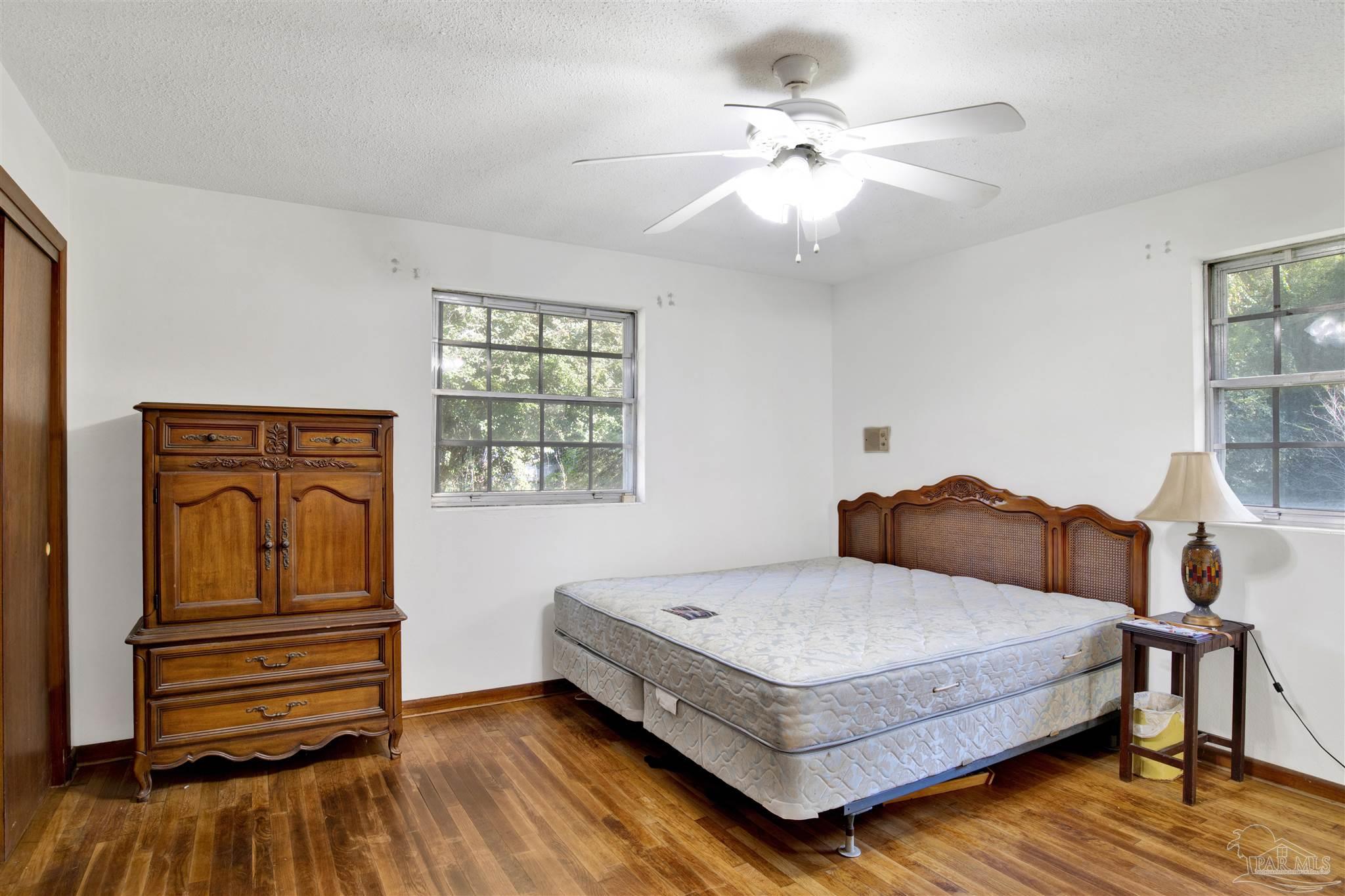 9621 Sidney Road Pensacola, FL 32507 - Photo 14 of 30 a bedroom with a bed and wooden floor