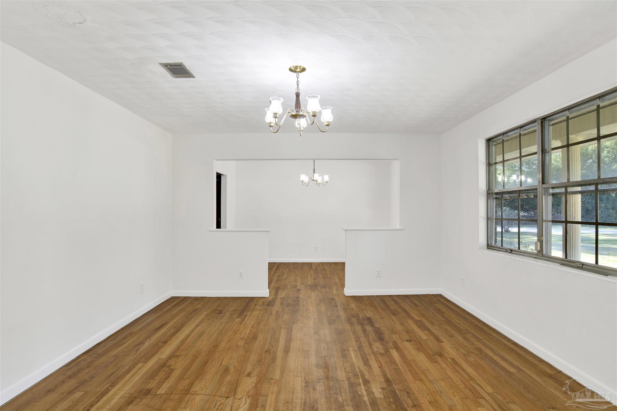9621 Sidney Road Pensacola, FL 32507 - Photo 22 of 30 a view of empty room with wooden floor and windows