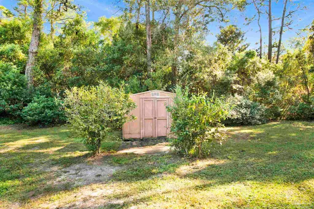 a backyard of a house with a yard and large trees