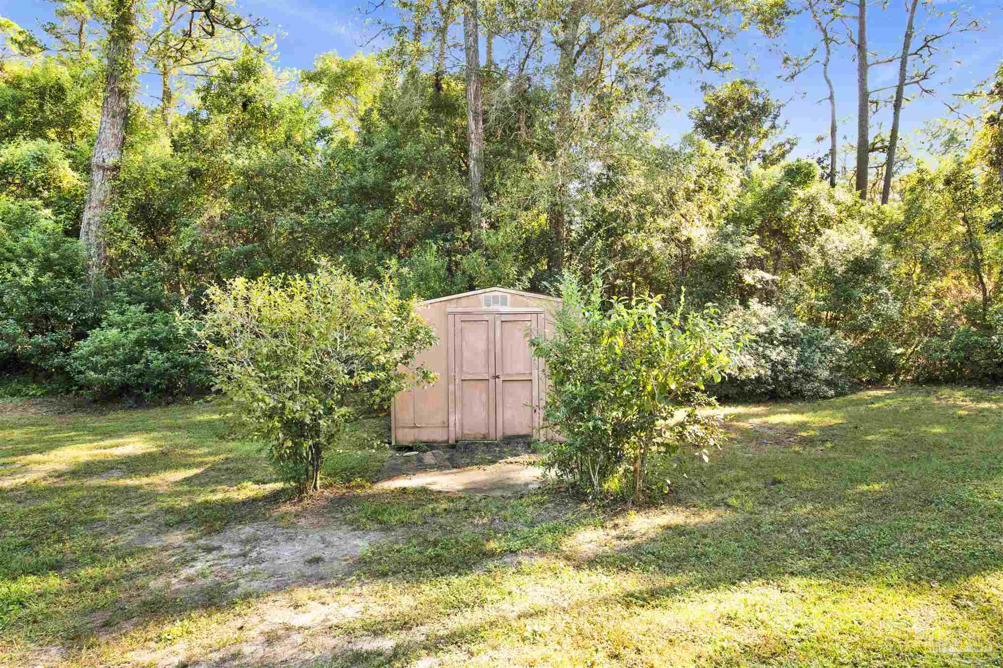 9621 Sidney Road Pensacola, FL 32507 - Photo 30 of 30 a backyard of a house with a yard and large trees