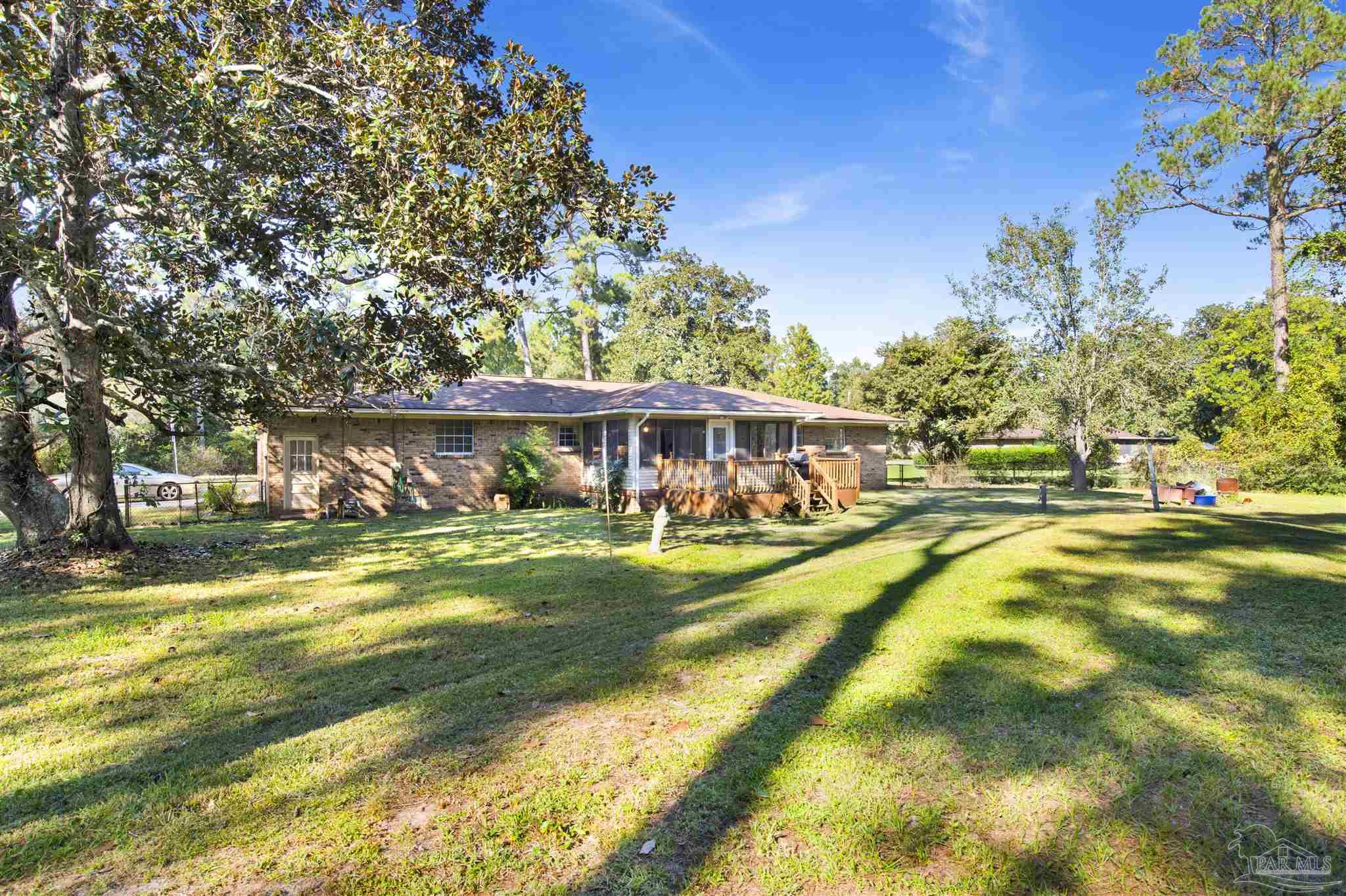 9621 Sidney Road Pensacola, FL 32507 - Photo 3 of 30 a view of swimming pool with lawn chairs and large trees
