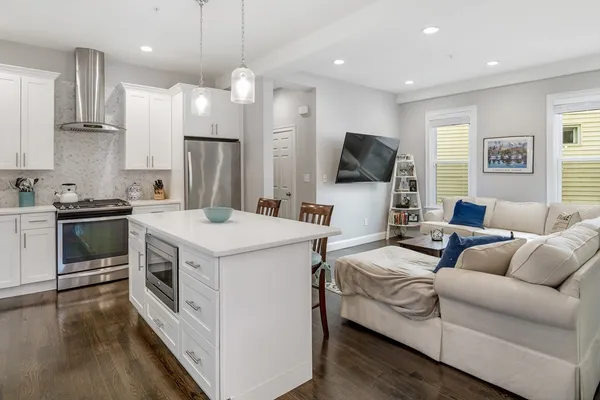 a kitchen that has a lot of cabinets a sink and a wooden floor