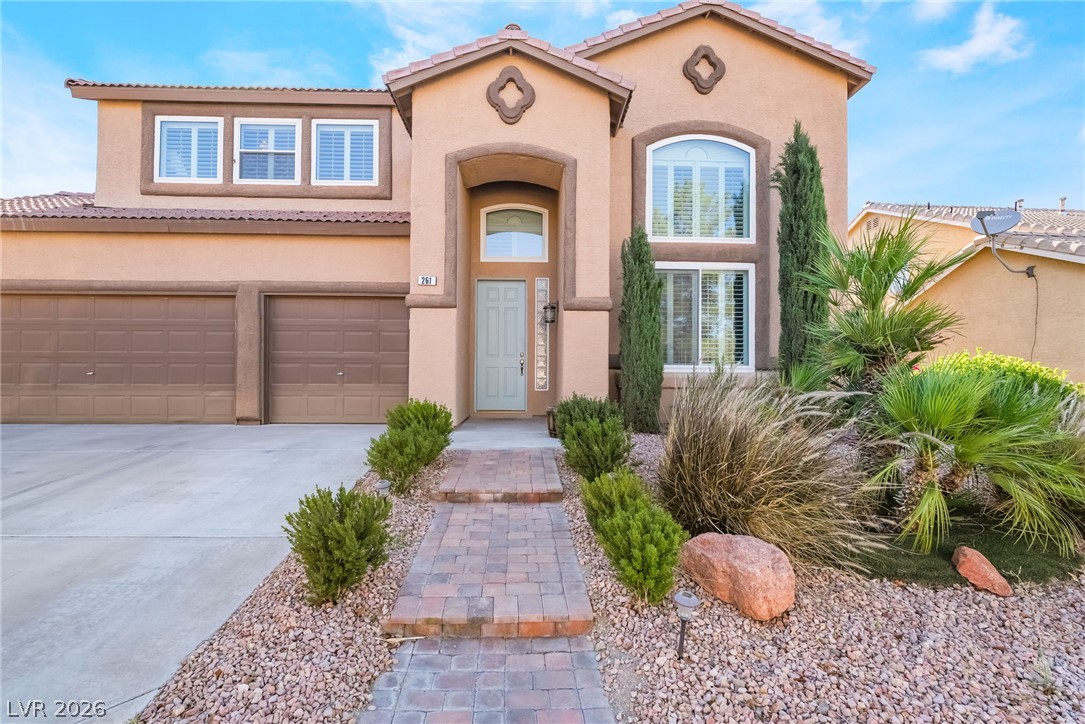261 Timber Hollow Street Henderson, NV 89012 - Photo 6 of 51 A terracotta-hued facade with arched entryways and well-tended desert landscaping welcomes all.