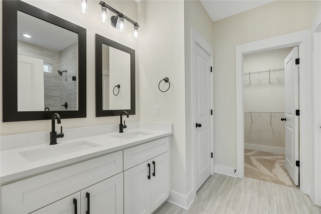 100 Garden Gate Drive Anderson, SC 29621 - Photo 23 of 43 This sleek bathroom features a double vanity and a spacious walk-in closet, offering both style and functionality.