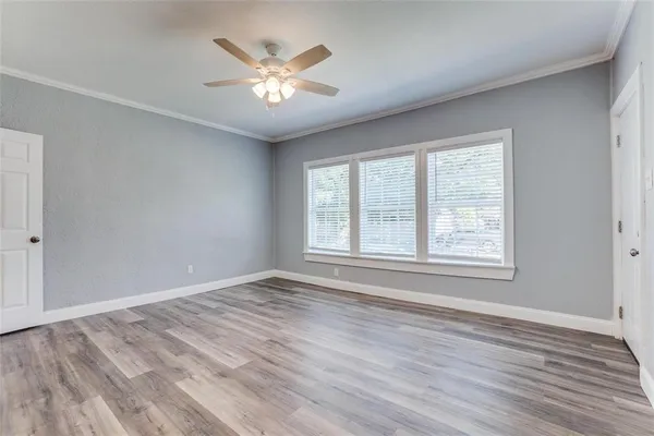 a view of an empty room with a window and wooden floor
