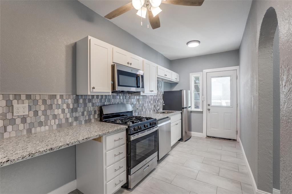 320 West Canty Street, Unit 2 Dallas, TX 75208 - Photo 6 of 11 a kitchen with granite countertop a stove top oven a sink dishwasher and a microwave oven on the blue kitchen countertops