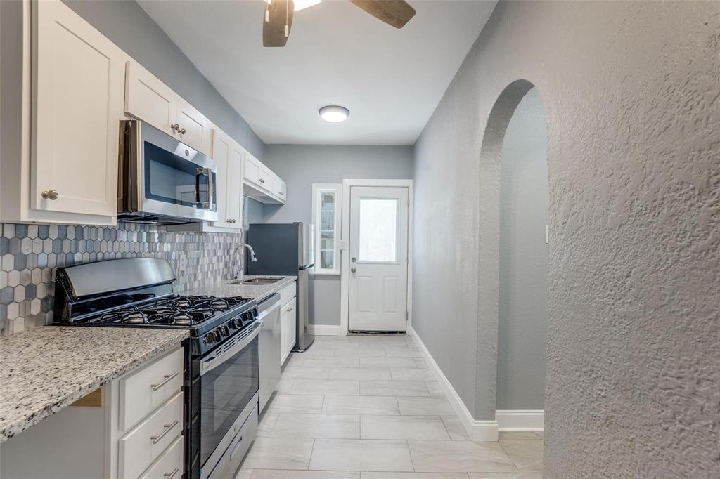 320 West Canty Street, Unit 2 Dallas, TX 75208 - Photo 8 of 11 a kitchen with stainless steel appliances granite countertop a stove a sink and a microwave