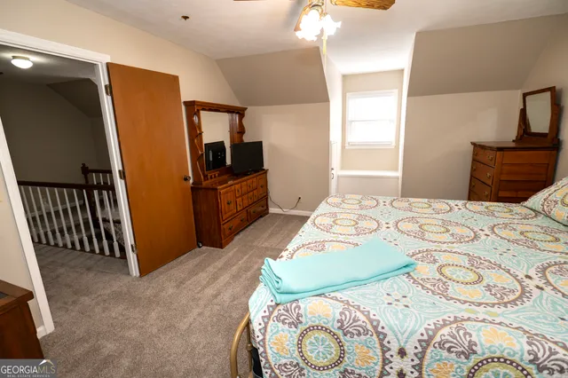 a view of staircase with lots of frames on wall and windows