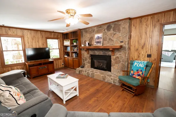 a living room with furniture a flat screen tv and a fireplace