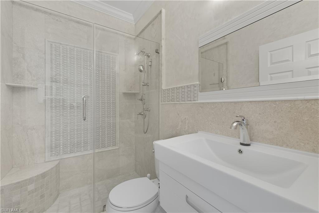 326 Bradstrom Circle, Unit 203F Naples, FL 34113 - Photo 13 of 24 a bathroom with a sink a toilet and shower