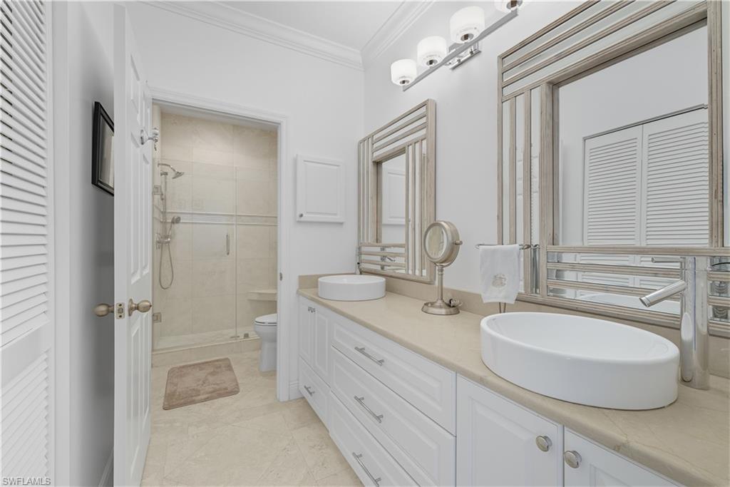 326 Bradstrom Circle, Unit 203F Naples, FL 34113 - Photo 14 of 24 a bathroom with a double vanity sink mirror and shower