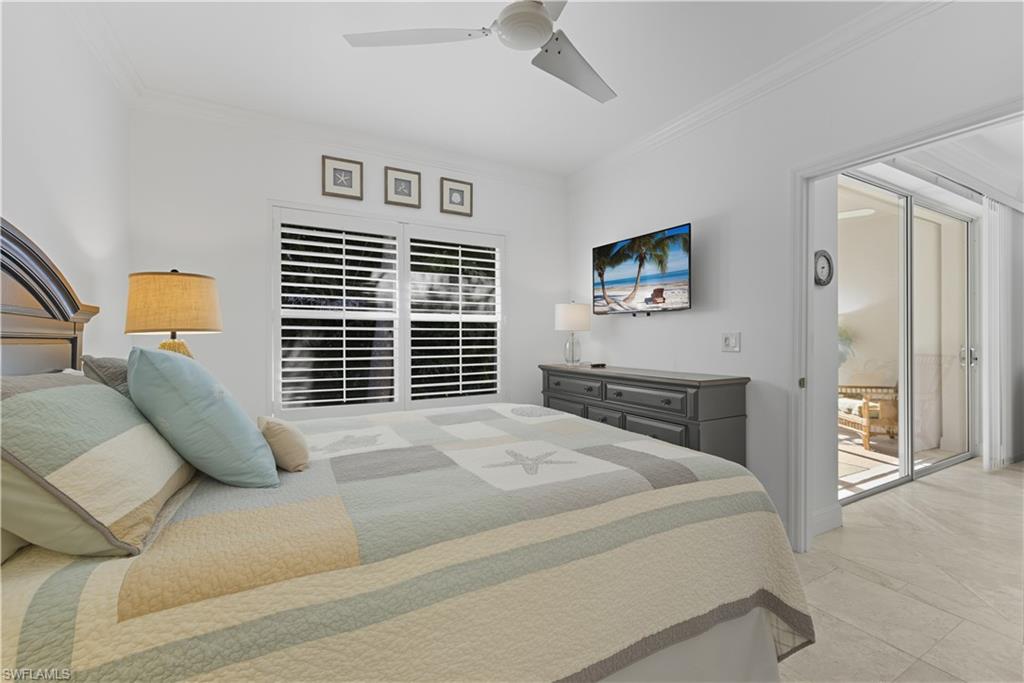 326 Bradstrom Circle, Unit 203F Naples, FL 34113 - Photo 17 of 24 a bedroom with a bed and a flat screen tv