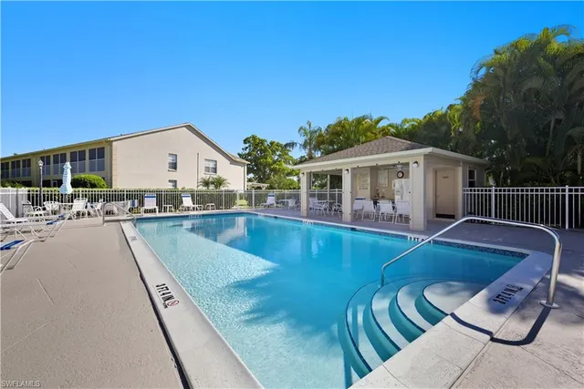 a view of a house with pool and chairs