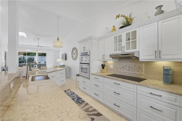 a kitchen with stainless steel appliances kitchen island granite countertop a sink a stove and cabinets