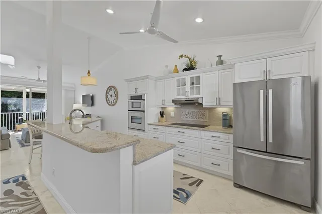 a kitchen with refrigerator cabinets and living room
