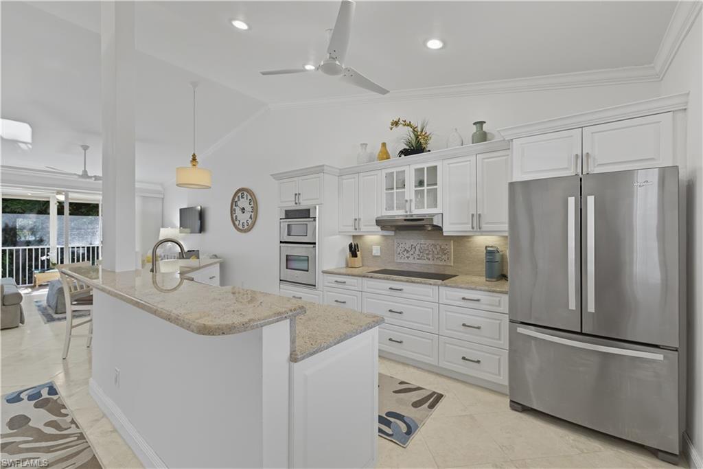 326 Bradstrom Circle, Unit 203F Naples, FL 34113 - Photo 6 of 24 a kitchen with refrigerator cabinets and living room