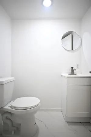 a white toilet sitting next to a bathroom sink