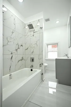 a bathroom with a bathtub a toilet and a shower