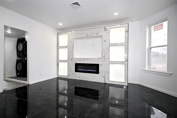 a view of an empty room with a fireplace and a window