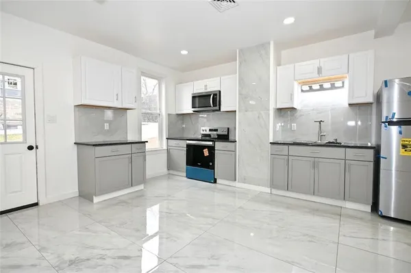 a kitchen with granite countertop a refrigerator and a sink