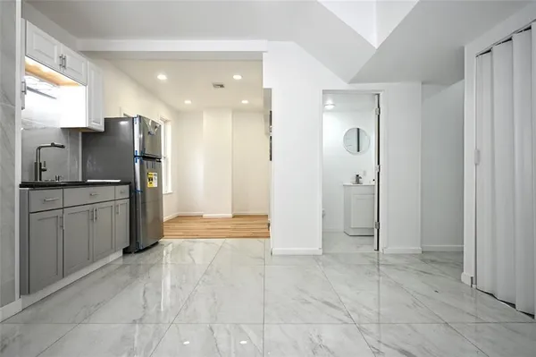 a view of a kitchen with refrigerator and wooden floor