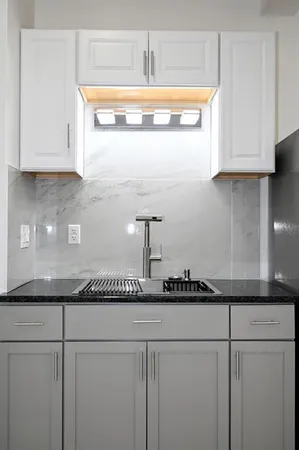 a kitchen with granite countertop cabinets and white stainless steel appliances