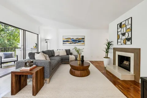 a living room with furniture a fireplace and a large window