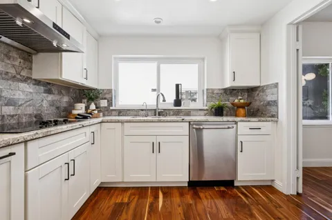 a kitchen with white cabinets and white appliances