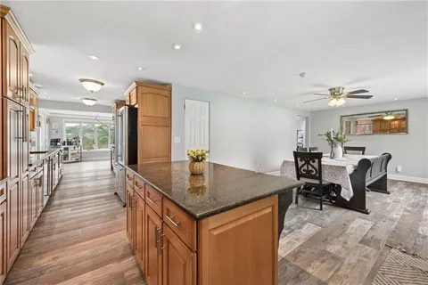 a dining hall with stainless steel appliances granite countertop a granite counter tops and a view of living room