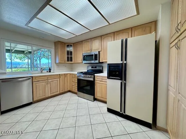 a kitchen with stainless steel appliances a refrigerator sink and microwave