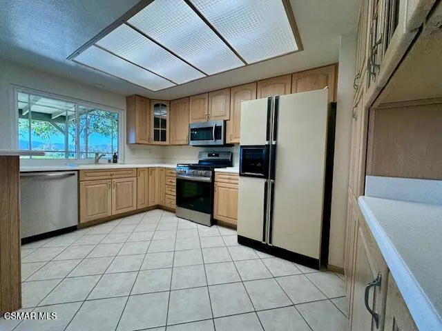 a kitchen with stainless steel appliances a refrigerator sink and microwave