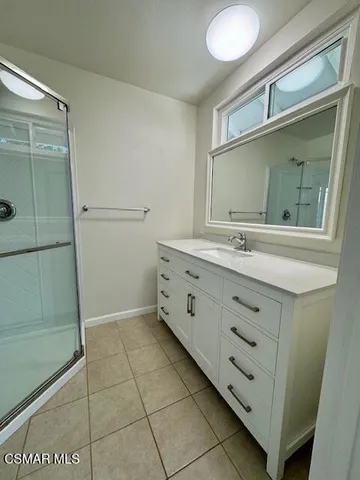 a bathroom with a double vanity sink mirror and shower