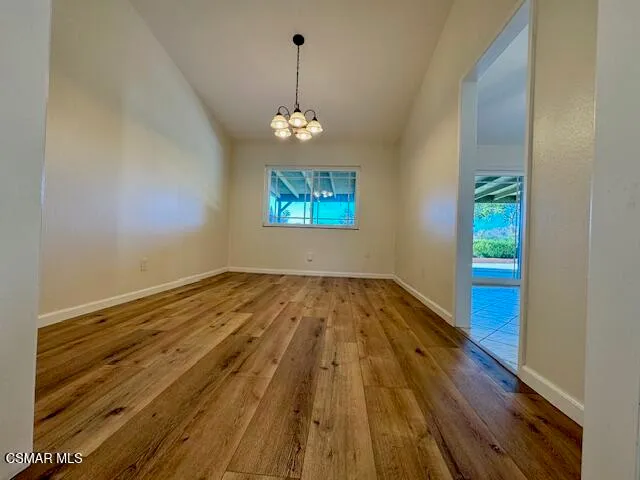 a view of empty room with wooden floor and window