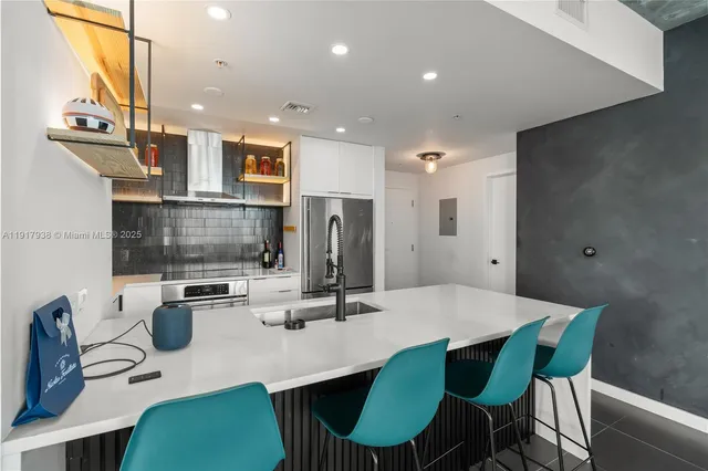 a kitchen with a dining table chairs and a refrigerator