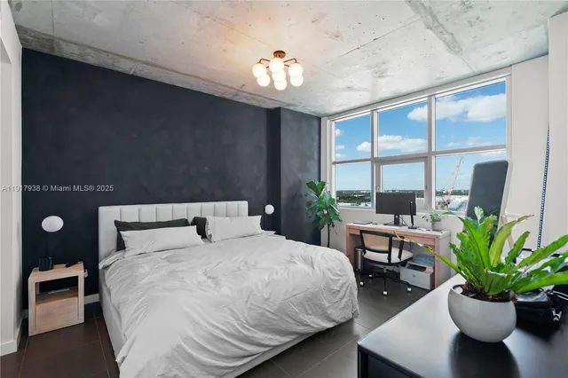 a bedroom with a large bed and a potted plant