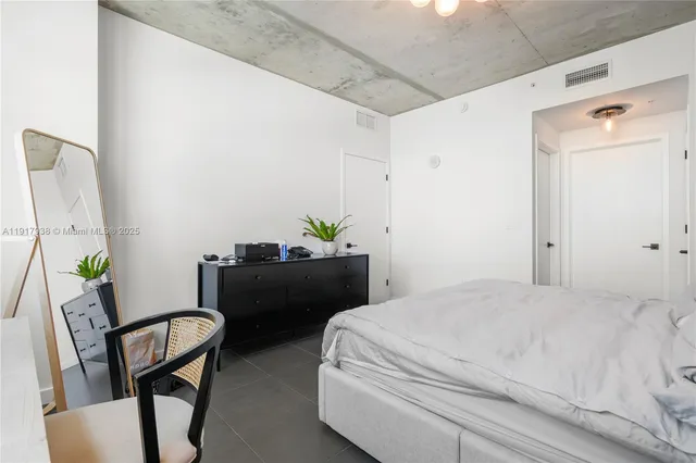 a bedroom with a bed chair and window